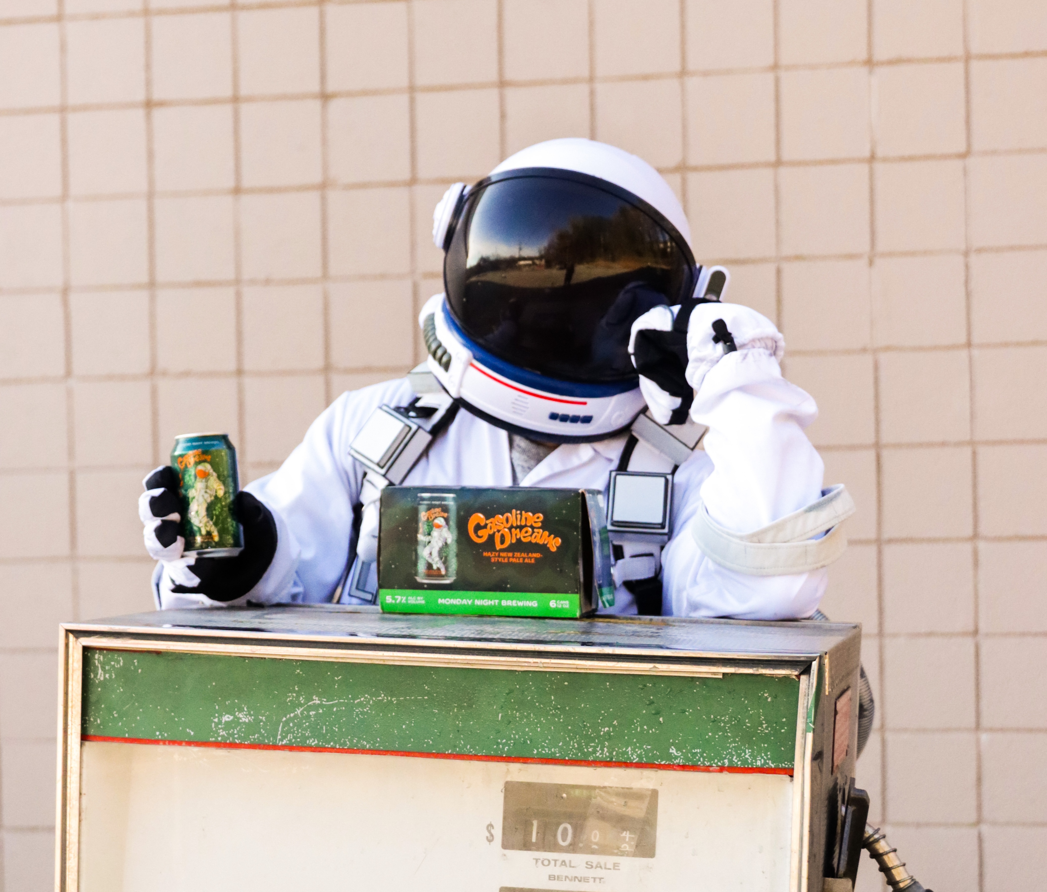 Hopstronaut character holding a Gasoline Dreams can at a vintage gas pump